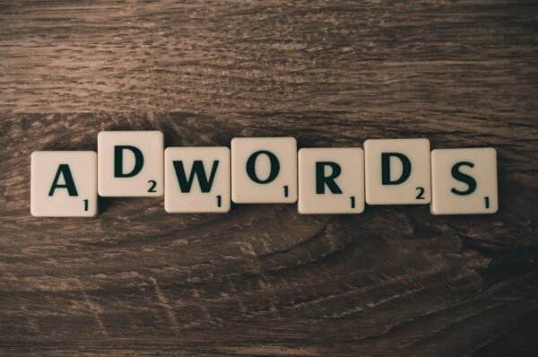 Scrabble Forming Adwords on Brown Wooden Surface